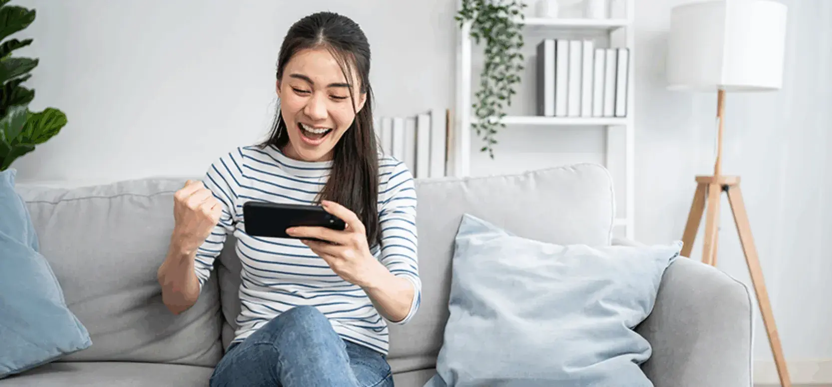 Girl looks at mobile phone and pumps fist